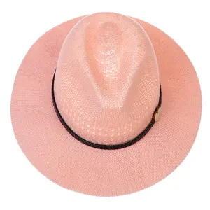 Detailed weave texture of pink straw fedora hat with black band and heart charm
