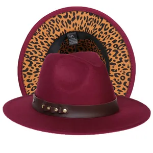 Dettaglio del cappello fedora bordeaux con cinturino in pelle, borchie dorate e tesa leopardata
