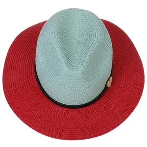 Close-up of two-tone straw hat with mint crown, red brim and small heart detail