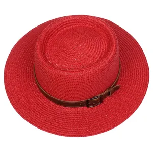 Close-up of red straw boater hat with fine weave texture and brown decorative band