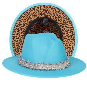 Dettaglio del cappello fedora blu con tesa leopardata e nastro decorato con perle