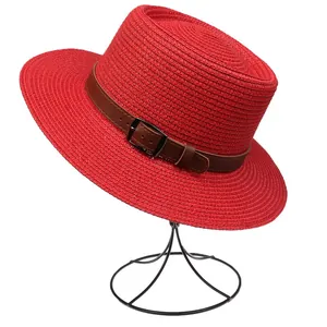 Close-up of red straw hat featuring a woven texture and brown faux leather band detail