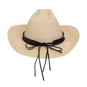 Nahaufnahme eines beigen Stroh-Cowboyhutes mit schwarzem Lederband und Quastendetail