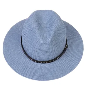 Detail of light blue straw panama hat with black studded band and woven texture