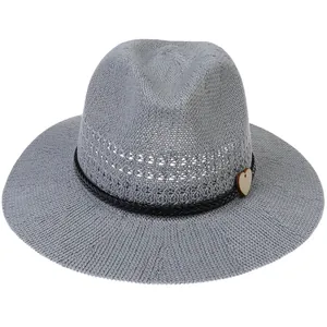 Detail of gray straw hat featuring hollow-out weave and heart-shaped wooden button