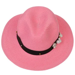 Détail du chapeau Panama tressé rose avec ruban noir orné de perles et de marguerites