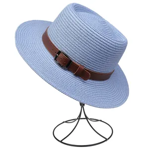 Detail of blue woven straw hat featuring brown faux leather strap and metal buckle