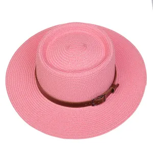 Detailed top view of pink straw boater hat with brown leather band and metal buckle strap