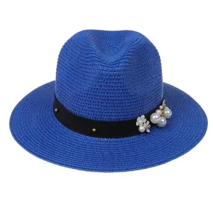 Détail du chapeau Panama bleu roi avec perles et fleurs sur ruban noir élégant