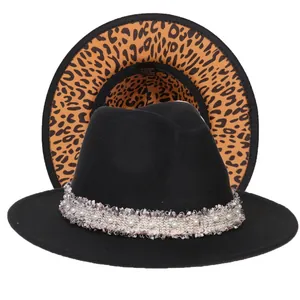 Dettaglio del cappello fedora nero con tesa a macchiato e nastro con perle e frange fini