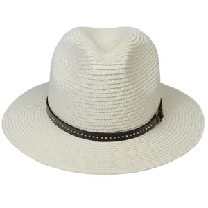 Close-up of white woven Panama hat with black decorative band and metallic rivets