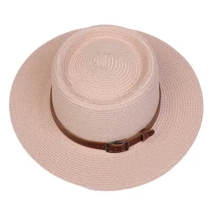 Detail of light pink straw sun hat with leather band buckle and fine weave texture