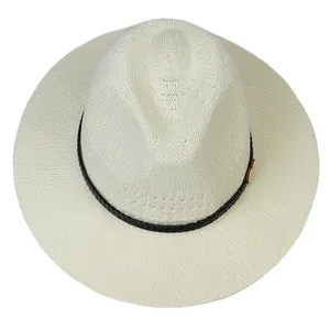 Close-up of cream woven straw hat texture with black band and decorative wood button