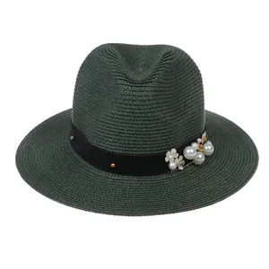 Détail du chapeau Panama vert foncé avec perles et fleurs sur ruban noir élégant