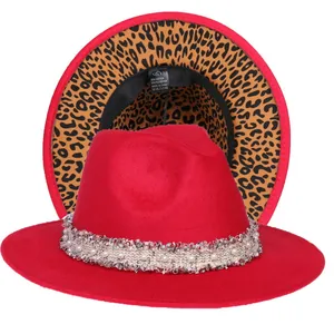 Dettaglio di cappello fedora rosso con fascia di perle e fodera interna leopardata