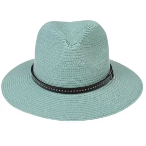 Detailed close-up of mint green straw Fedora hat with studded leather band and woven texture