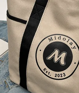 Detalle del bolso tote de lona blanco roto con tela densa y logotipo en contraste
