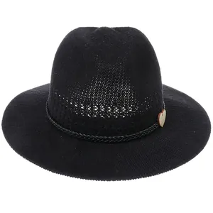 Close-up of black breathable straw hat with woven band and heart-shaped wooden charm