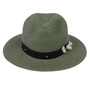 Détail d'un chapeau Panama en paille verte avec fleurs en perles et ruban gros-grain