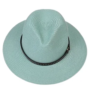 Detail of mint green straw fedora hat featuring a studded black leather decorative band