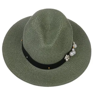 Détail du chapeau Panama vert foncé avec ruban gros-grain noir et accents de perles