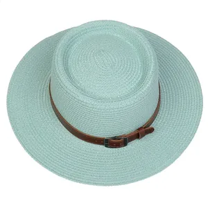 Detailed top view of mint green straw hat with woven texture and brown leather band
