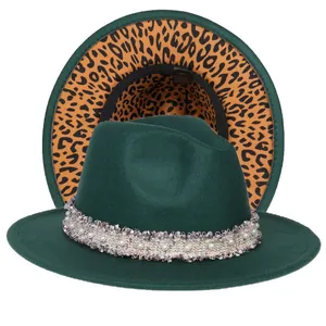 Dettaglio del cappello fedora verde scuro con fascia di perle e fodera leopardata
