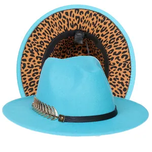 Dettaglio cappello fedora blu con bordo leopardato e decorazione con piuma dorata