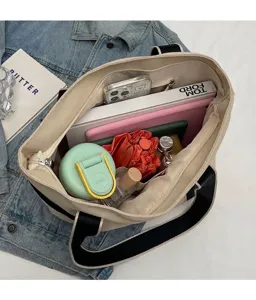 Detail view of a large canvas tote bag interior with multiple compartments and zip pocket