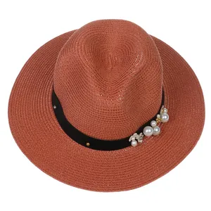 Vue de dessus du chapeau Panama orange rouille avec perles et ruban fleuri