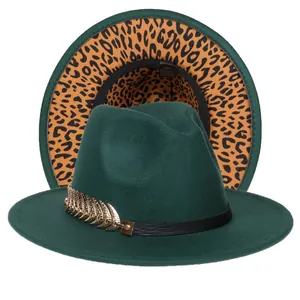 Dettaglio del fedora verde scuro con fascia in pelle, piuma d'oro e tesa maculata