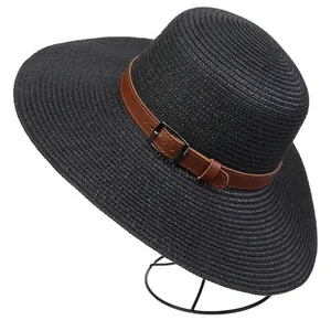 Detail of black woven straw hat featuring a brown faux leather belt and metal buckle