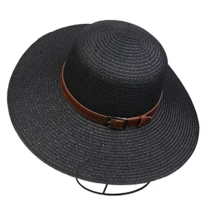 Detail of black woven sun hat featuring a brown leather strap and metal buckle