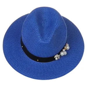 Détail du chapeau Panama bleu avec perles, billes dorées et décorations florales