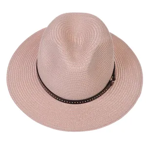 Detail of light pink straw Fedora with brown leather band and metal rivet accents