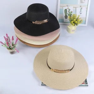 Flat lay of foldable wide brim straw hats in four colors with gold feather buckles