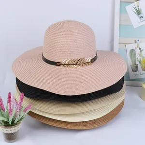 Detail showing four assorted colors of wide-brim woven straw hats with metal leaf buckle