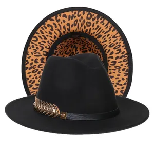 Dettaglio cappello fedora nero con tesa leopardata e accessorio piuma dorata