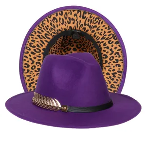Dettaglio del cappello fedora viola con fodera leopardata e ciondolo a piuma dorata