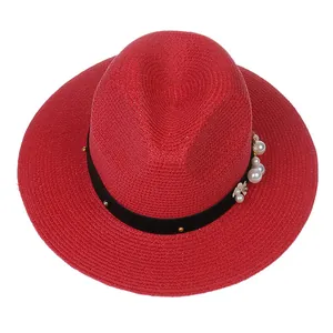 Détails du chapeau de paille rouge avec perles et ruban noir orné de clous