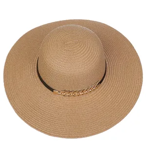 Close-up of woven straw hat texture with black band and gold feather ornament