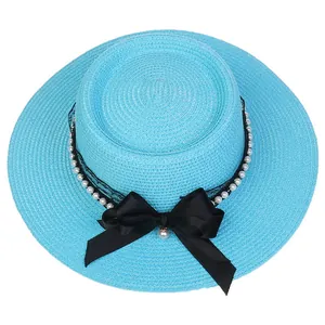 Detail of sky blue straw hat featuring black lace, silk bow, and faux pearl charms