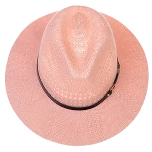 Close-up of pink woven straw hat texture with classic black band and metallic buckle