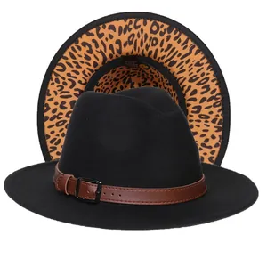 Dettaglio del cappello fedora nero con tesa leopardata e cinturino in pelle marrone
