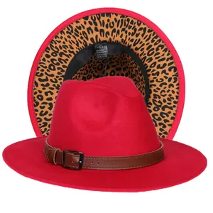 Dettaglio del cappello fedora rosso con tesa leopardata e cinturino in pelle con fibbia
