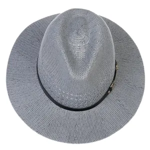 Macro detail of mid-grey woven fedora hat with black decorative band and gold buckle