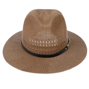 Close-up of summer straw fedora hat featuring a black leather band and gold buckle detail
