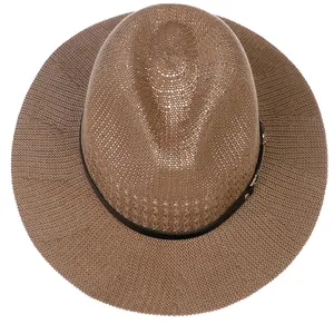 Top view of brown woven straw hat with black ribbon detail for summer beach vacation