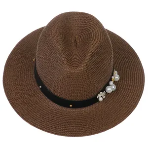Détail d'un chapeau Panama marron avec tissage en paille et ruban orné de perles fines