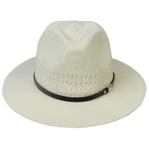 Detail of hollow-out straw fedora featuring a black leather band and golden buckle